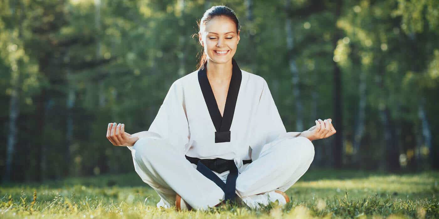 Martial Arts Lessons for Adults in Roy UT - Happy Woman Meditated Sitting Background